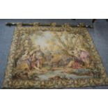 An 18th century style machine made hanging tapestry, with gilt metal rail