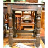 A late 17th/early 18th century oak joint stool with turned legs, the underside of the top engraved