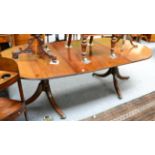 A reproduction twin pedestal dining table in solid mahogany, with one leaf