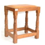 A Robert ''Mouseman'' Thompson Oak Dressing Table Stool, with upholstered cow hide seat, on four