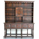 An Oak Dresser and Rack, the bold cornice above a wavy shaped apron with fixed shelves above a