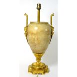 A Gilt Metal Mounted Onyx Lamp Base, in Regency style, of ovoid form with loop and mask handles on