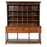 An 18th Century Oak Dresser and Rack, the bold cornice above iron cup hooks with three fixed shelves