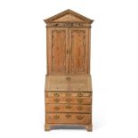 A George III Pine Bureau Bookcase, late 18th century, the architectural pediment above a flower