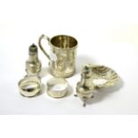 A silver christening mug, shell shaped bonbon dish, two napkin rings and two peppers 7.6ozt