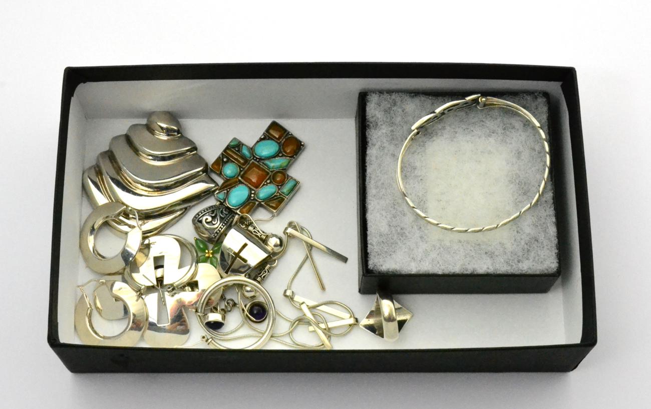 A collection of silver jewellery including a Mexican abstract brooch, a turquoise set cross, three