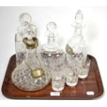 A group of four decanters including one silver collared example, three silver decanter labels and