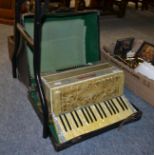 A piano accordion, a child's sewing machine and a cased dumpy level