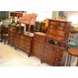 A group of furniture including a Victorian chair, tub chair, five chests of drawers, three