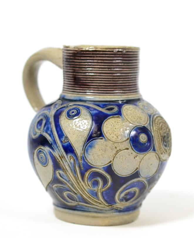 An 18th century Westerwald scratch blue jug, initialled 'GR', 11cm high