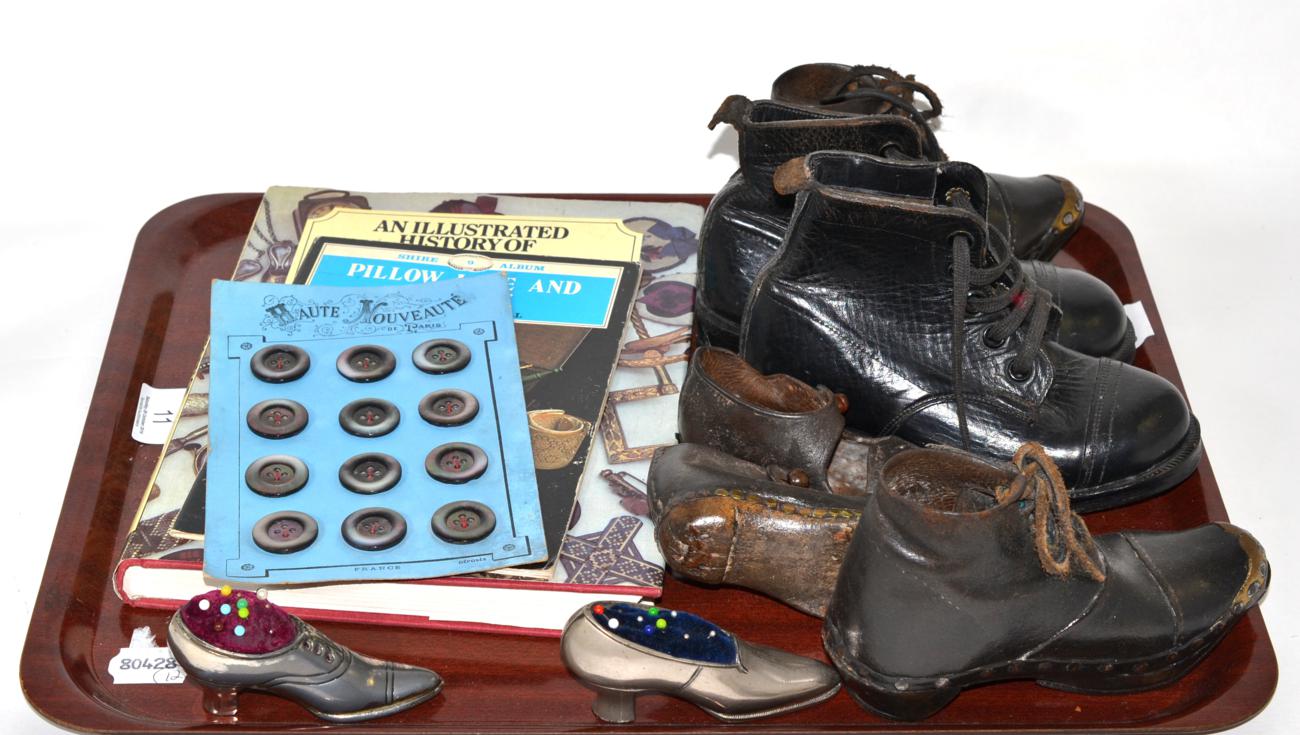 Pair of child's black leather lace up boots, two pairs of clogs, two shoe pin cushion, two books and