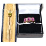 A pink stone diamond ring and a peridot stick pin