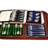 Three cased sets of silver spoons and a cased set of pickle forks