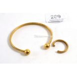 A 9ct gold torque bangle, a 9ct gold bond ring (cut a.f.)