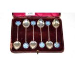 A cased set of six silver teaspoons with blue enamel floral terminals