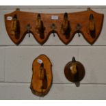 Deer slot coat rack; four deer slots (hoofs) mounted as coat hangers on a shaped oak fitting with