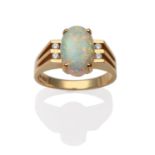 An Opal and Diamond Ring, an oval cabochon opal in a yellow four claw setting, between four round