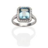 An 18 Carat White Gold Aquamarine and Diamond Ring, an emerald-cut aquamarine within a border of