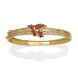 A Ruby and Diamond Bangle, the front section with a central knot of calibré cut rubies in yellow