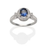 A Sapphire and Diamond Cluster Ring, an oval cut sapphire in a white four claw setting within a halo