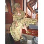 Doll in green dress with painted cardboard head and composite legs & arms