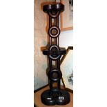 Oriental carved rosewood candlestand of turned rings linked to turned uprights, 23" tall on shaped