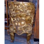 Far-Eastern gold-leafed chair made from a solid piece of teak with Hindu Deity face covering the