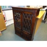A carved oak bookcase with leaded glass