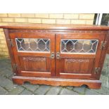 A carved oak music cabinet by Old Charm