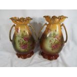 A pair of matched twin-handled ceramic vases decorated with roses,