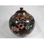 A good quality bulbous lidded pot on tripod feet decorated in a floral pattern 10cm (h)