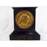 A cast iron cased mantel clock, large gilded dial with Arabic numerals, cast decorative bezel,