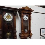 A Vienna style wall clock in a walnut case with carved and turned decoration,