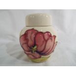 Moorcroft Pottery - a lidded ginger jar decorated with pink magnolia on an ivorine ground,