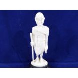 A 20th century carved ivory figure depicting Gandhi on a plinth, approximately 12.