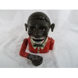 An original mechanical novelty money bank in the form of a black man,