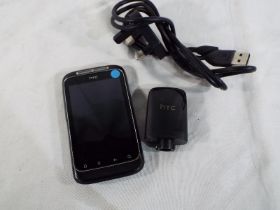 An HTC mobile telephone with charger, av