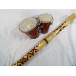 A Rainmaker 82 cm (l) and a pair of wooden bongos (2)