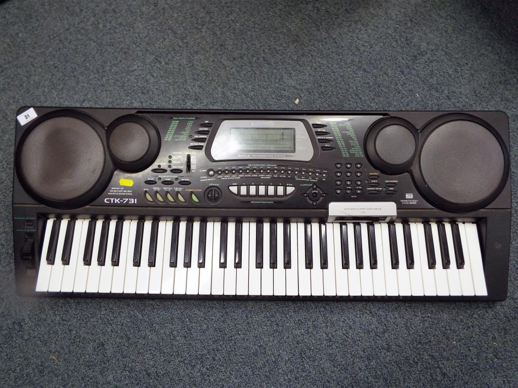 A Casio CTK-731 multi-function electronic keyboard together with a General Motors in-car 6-disc CD