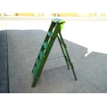 A wooden stepladder, painted green,