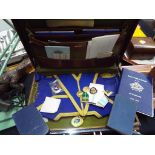 A brown leather case containing a collection of Masonic regalia to include medals, sash,