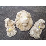 Stonework - a reconstituted stone wall plaque in the form of a lion's head and two ornamental