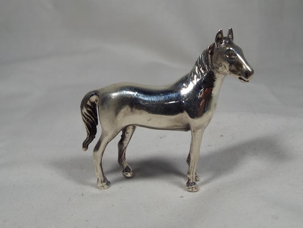 A white metal miniature figure in the style of a mare, stamped .