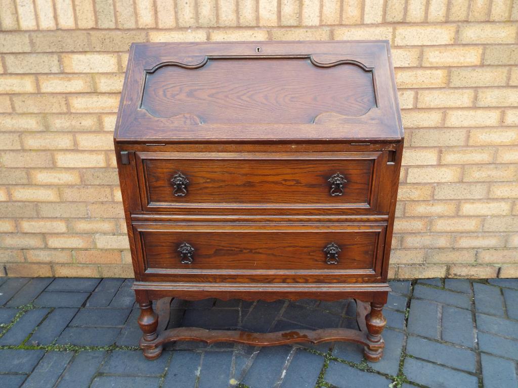 An oak bureau, the slope front opening to reveal a pigeon-hole fitted interior above two drawers, - Bild 2 aus 2