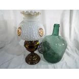 A large green glass bottle and a converted oil lamp