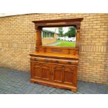 An Art Nouveau oak, mirror-backed sideboard with decorative carving,