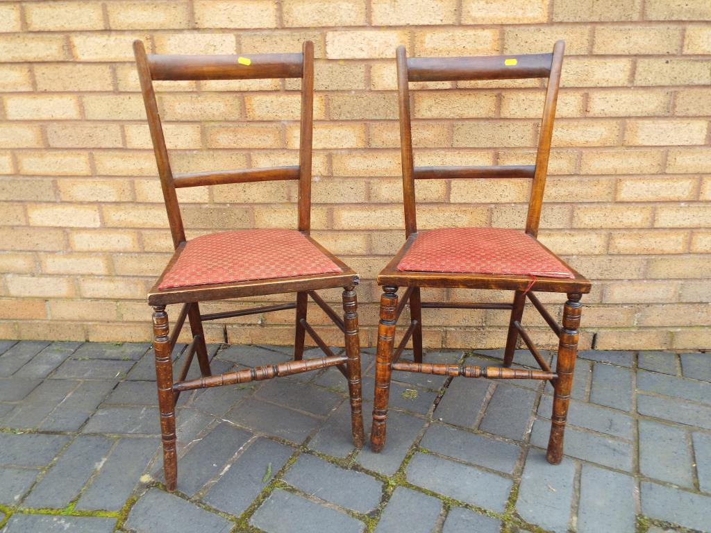 A pair of early 20th century chairs with upholstered red drop in seats,