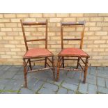 A pair of early 20th century chairs with upholstered red drop in seats,