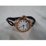 A lady's 9 carat gold wristwatch with ceramic fascia stamped 375 and leather strap.
