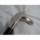 A good quality walking cane with a white metal handle depicting a horses head,